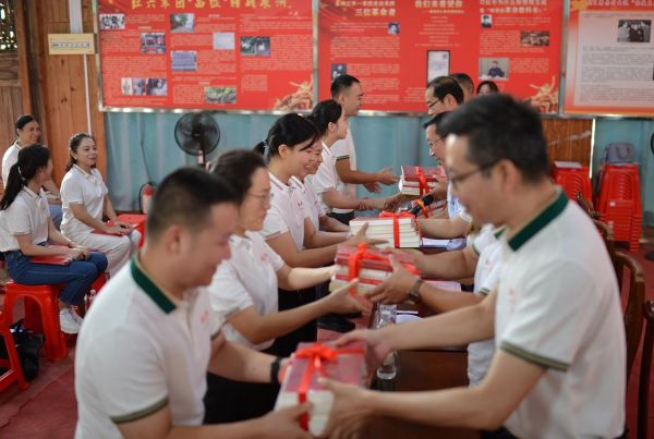 图为青年理论学习小组导师向青年干部赠送书籍