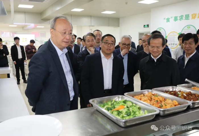 在育英学校食堂窗口查看校园餐菜品种类