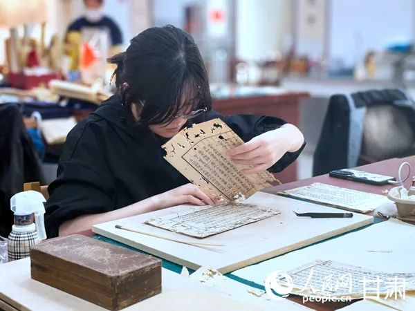 4月18日，甘肃省古籍保护中心，实习生正小心翼翼地进行书籍修复。人民网记者 周婉婷摄