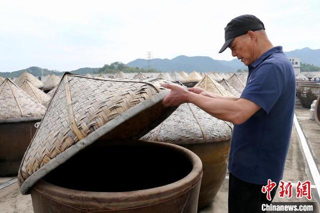 4月23日，酱油酿造师傅仔细查看酱醅发酵情况。中新社记者 项菁 摄