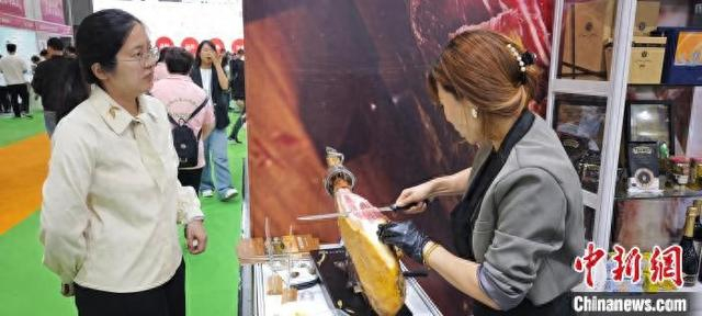 4月23日，火腿切片师为客户切下一片西班牙火腿。傅飞扬 摄