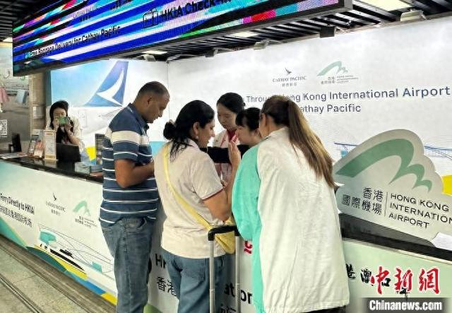 4月24日，两名境外采购商在第137届广交会香港国际机场服务柜台咨询相关业务。程景伟 摄