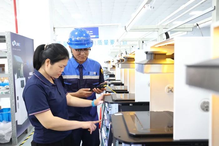 电信工程师为工厂调测光网。梁其琛 摄