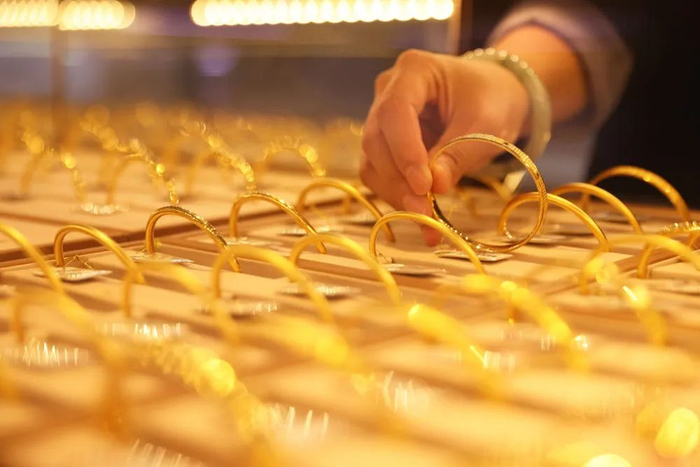 浙江省湖州市德清县乾元镇一家金店的营业员在整理黄金首饰。新华社发（倪立芳 摄）