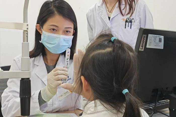 中山大学中山眼科中心屈光与青少年近视防控科主治医师许吉萍为患儿进行眼科诊查。新华社记者 徐弘毅 摄