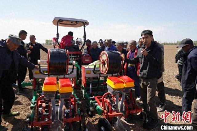 春耕时节，在阳高县龙泉镇八里台村，专业技术人员为农户们示范讲解玉米机械化播种技术和农机北斗应用技术等。周振宇摄