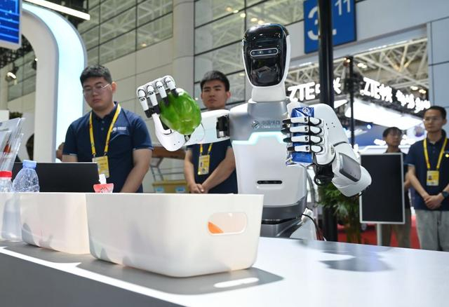 第八届数字中国建设峰会4月29日在福州开幕。这是中国移动展位的机器人“小智”在现场操作表演。新华社记者 林善传 摄