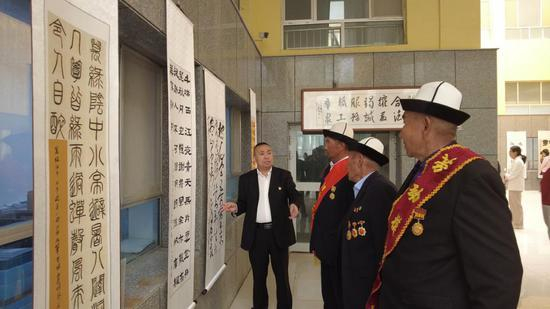 图为：劳模在作品前驻足欣赏 于赛克摄