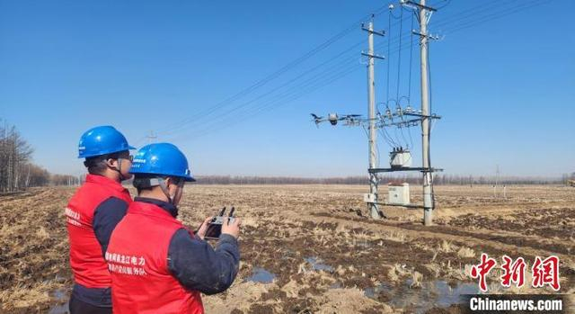 电力工作人员操控无人机查看各区域情况 唐丽慧 摄