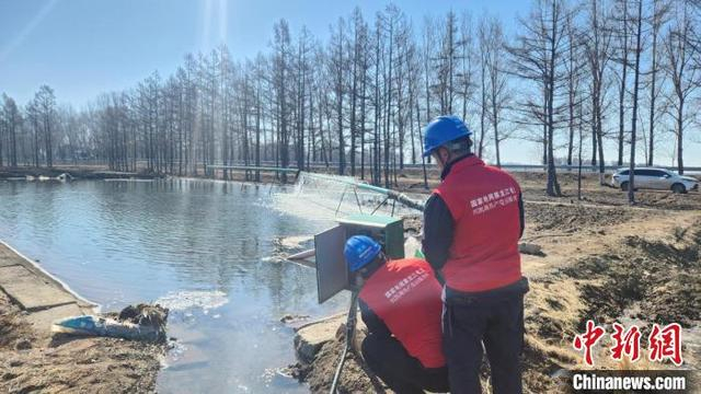 电力工作人员将浸在水里的电缆接头重新包扎固定 唐丽慧 摄