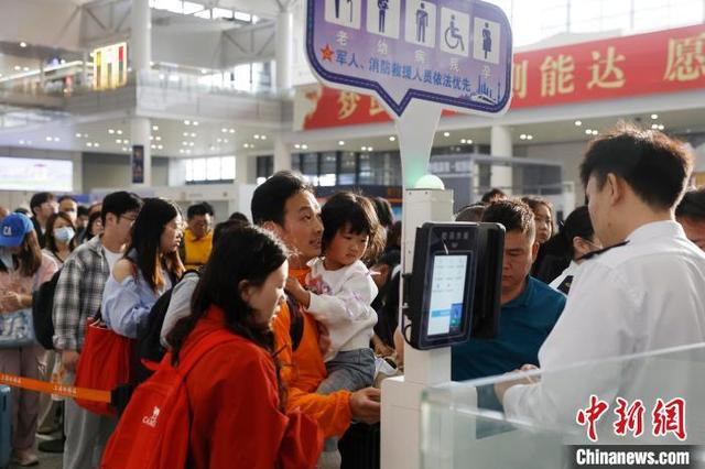 旅客带着孩子在铁路上海虹桥站验票上车。中新网记者 殷立勤 摄