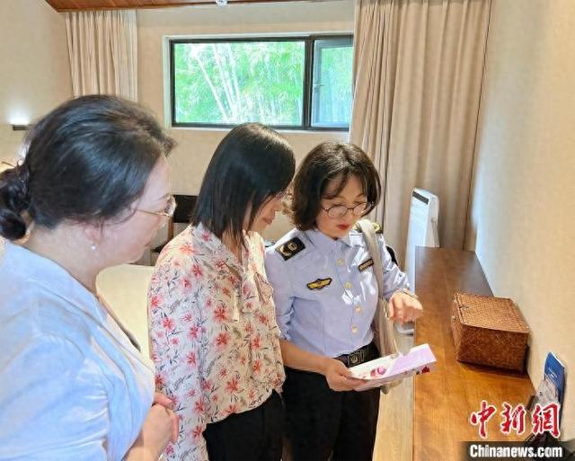 定海区市场监管部门工作人员在向民宿管理人员讲解《海岛酒店、民宿化妆品安全使用管理规范》相关内容。 葛彪摄