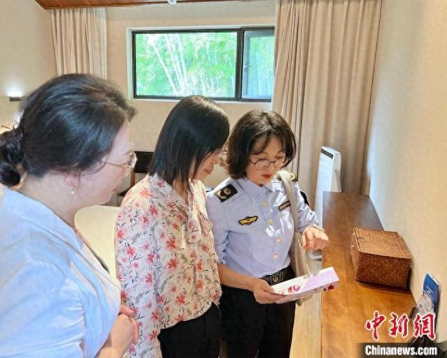 定海区市场监管部门工作人员在向民宿管理人员讲解《海岛酒店、民宿化妆品安全使用管理规范》相关内容。 葛彪摄