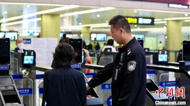上海虹桥边检站执勤人员引导旅客通过快捷通道。吴晓蕾 摄