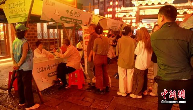 游客正在中医义诊摊位前把脉问诊。樟树市委宣传部供图