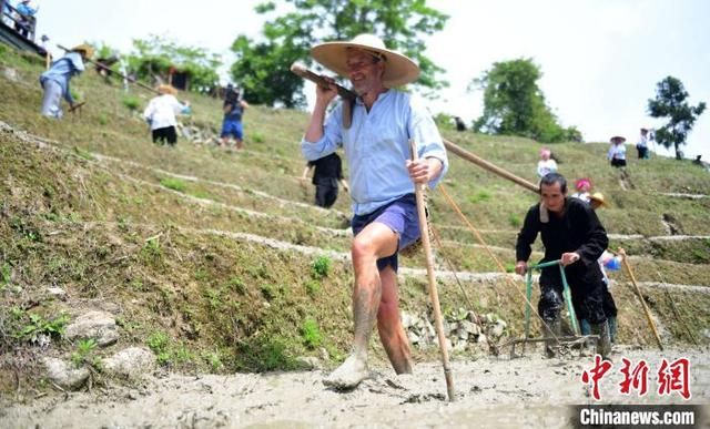 5月2日，在广西桂林市龙胜各族自治县龙脊古壮寨，外国游客在体验农耕劳作。潘志祥 摄