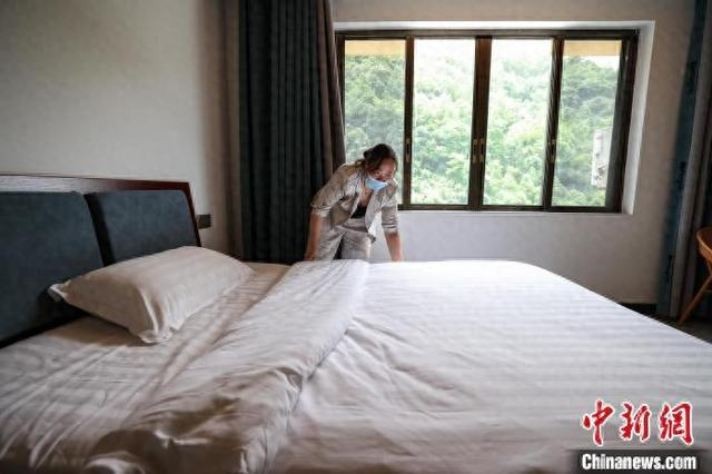 5月2日，遵义市绥阳县温泉镇公平村的村民陈英在收拾民宿客房。 中新社记者 瞿宏伦 摄