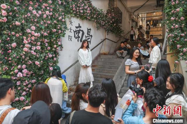 5月2日，江西南昌东湖区，游客在大士院老街的一处打卡墙前拍照。中新社记者 刘力鑫 摄