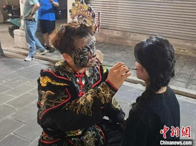 英歌舞队员5月2日在汕头小公园开埠区“学英歌·集五福”活动上为游客免费绘制英歌舞脸谱。 林大森 摄