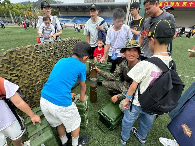 图为士兵为孩子们讲解炮弹知识。(记者富子梅摄)
