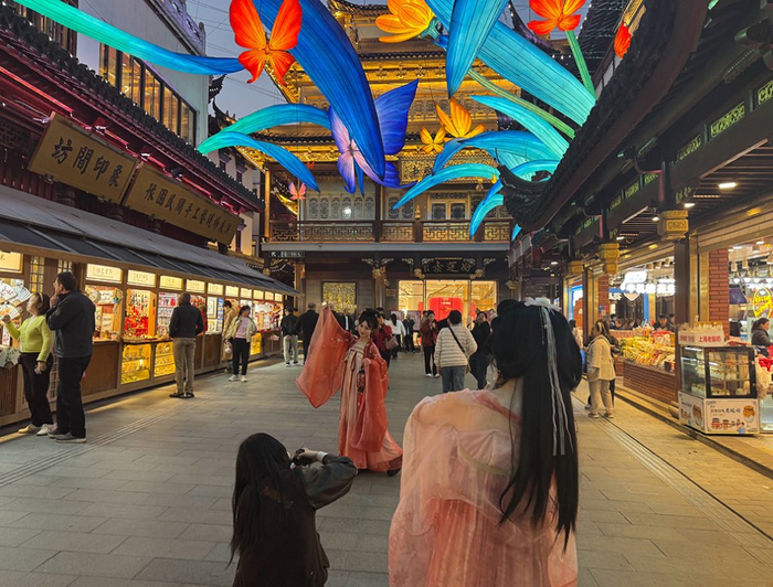 2025年仲春花朝节期间，上海豫园商城凝晖路上，来自日本东京的Kaede和朋友在豫园体验汉服摄影。澎湃新闻记者 李菁 图