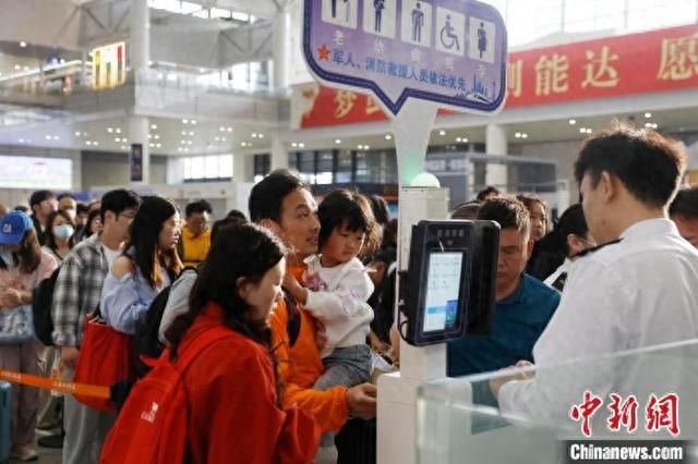 旅客带着孩子在铁路上海虹桥站验票上车。中新网记者 殷立勤 摄