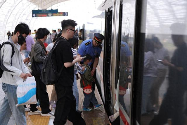 无锡东站工作人员帮助重点旅客登车。 高鹏 摄