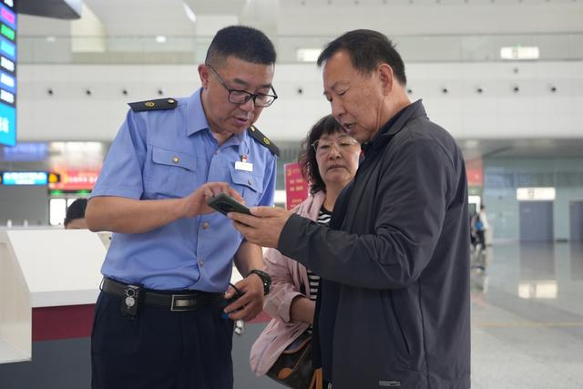 休班党员在阜阳西站为旅客答疑解惑。张续亮 摄