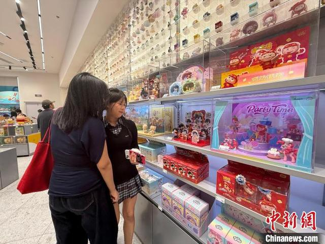 5月2日，游客在江西南昌一商圈“谷子店”内选购心仪的“谷子”。刘思伟 摄