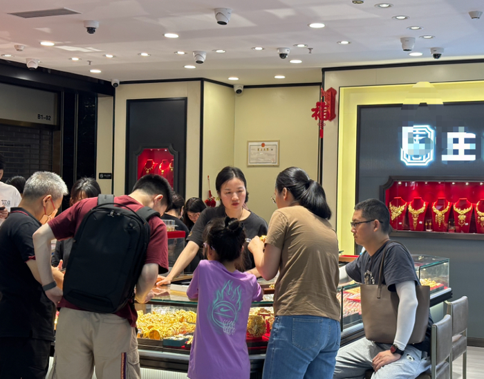 （消费者五一在水贝选购黄金。摄影 /王方然）