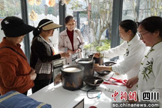 游客品尝中医药膳。 胡宇 摄