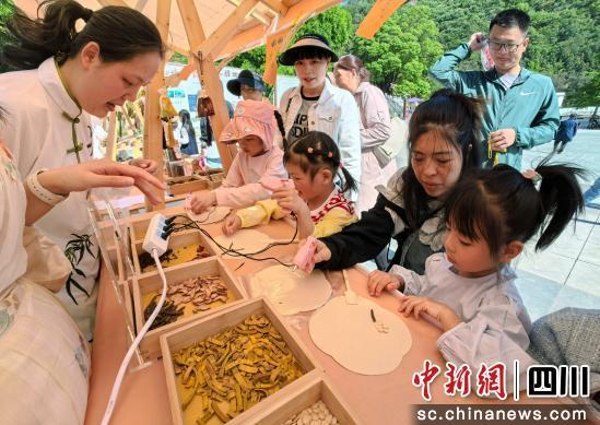 游客体验制作中药手工扇。 胡宇 摄