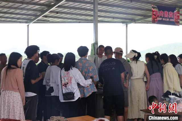 五一期间，游客在双龙烧烤城摊位前排队等候。墨江融媒 供图