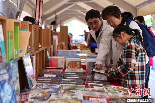 图为在辽宁出版集团楼前广场读者在选购图书。中新社记者 于海洋 摄