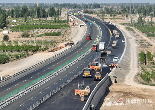 G30连霍高速改扩建哈密至吐峪沟段第10标段施工人员在摊铺沥青。曹鹏摄