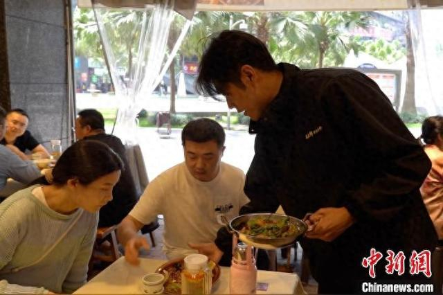 近日，陈德兴在餐馆服务顾客。记者 吕杨 摄
