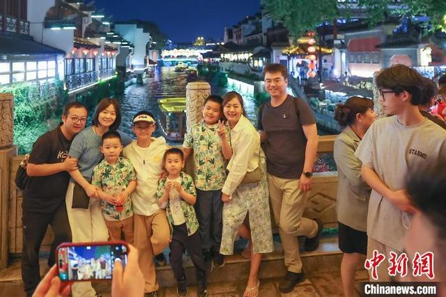 5月4日晚，江苏南京，游客在秦淮河文源桥上留影。中新社记者 泱波 摄