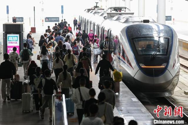 图为旅客在贵阳北站月台登车。中新社记者 瞿宏伦 摄