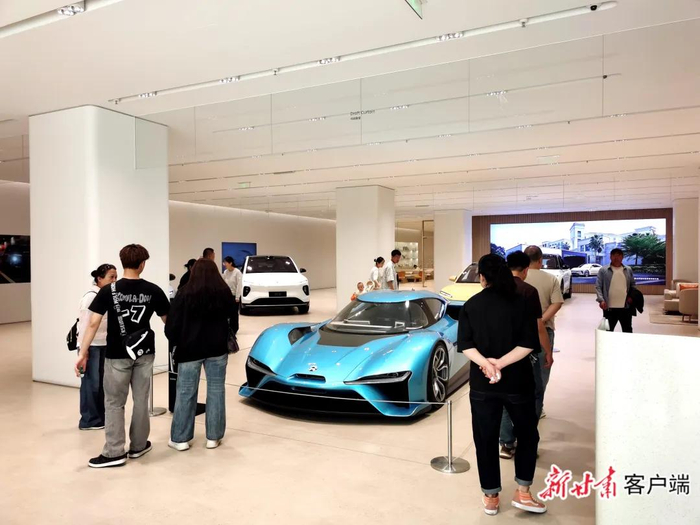 消费者走进新能源汽车体验店了解车市行情。