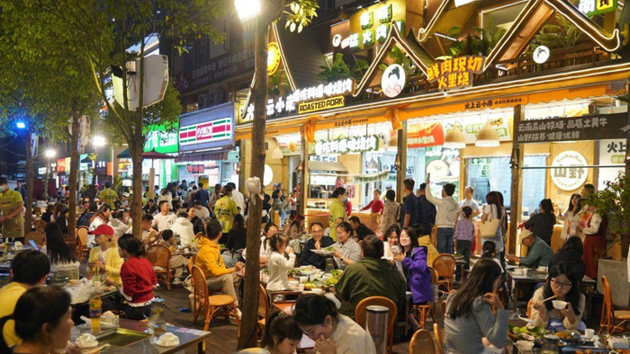 5月1日，游客在昆明市特色夜市街区南强街巷品尝美食。新华社 图