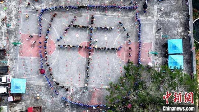图为村民用铜鼓组成巨大的“牛”字铜鼓阵。高东风 摄