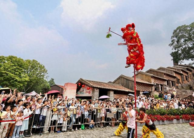 5月2日，在广东省佛山市禅城区南风古灶旅游休闲街区，游客在观看醒狮表演。新华社发（黄继明 摄）