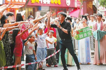 5月3日，在乐山市上中顺特色文化街区，游客观看文化快闪节目表演。李华时 摄（C视觉）