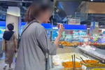 女子用公筷试吃超市咸菜后插回