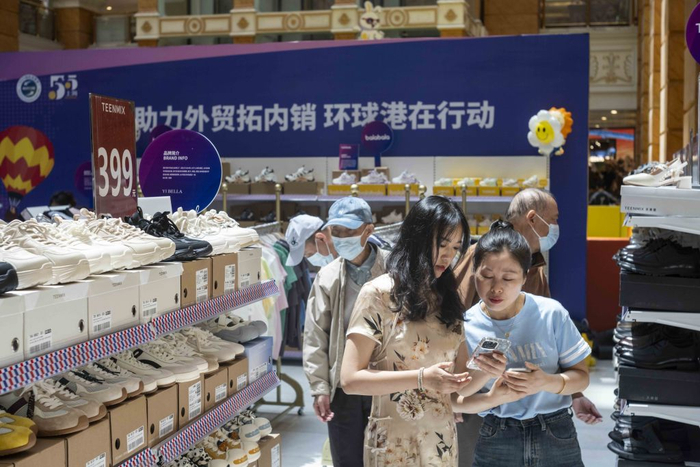 2025年5月4日，环球港出口转内销展销会现场，一名外地游客购买了一双鞋子，她向售货员展示手机中的支付订单。