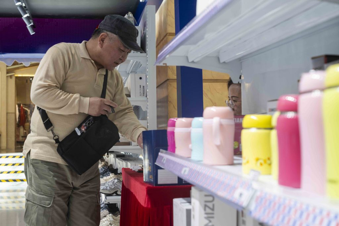 2025年5月4日，环球港出口转内销展销会现场，一名消费者在结算中。