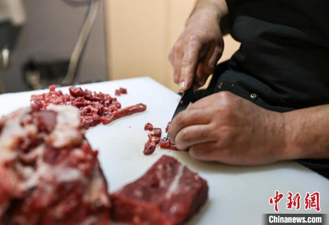 图为工作人员在切肉。中新社记者 于海洋 摄