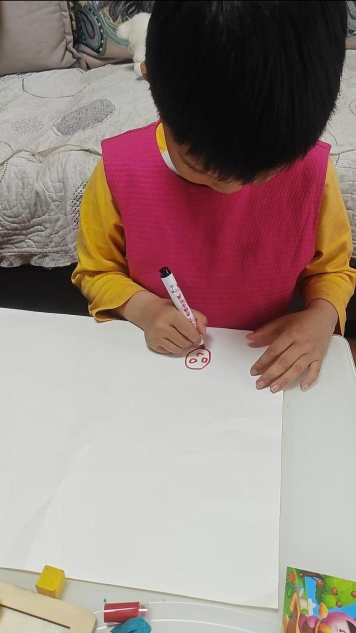 ▲奶娃在画“爸爸”“妈妈”