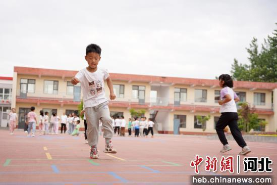 图为5月14日，河北省邢台市内丘县五郭店中心小学学生在操场上跳方格。 刘媛媛 摄