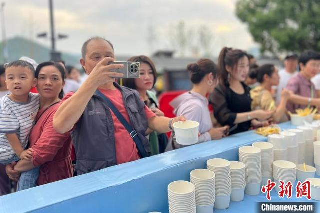 5月16日，一名游客品尝肥鱼火锅后拍照留念。郭晓莹 摄 